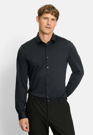 Black long-sleeve button-up shirt in a smooth fabric, featuring a classic collar and subtle sheen, paired with tailored black trousers.