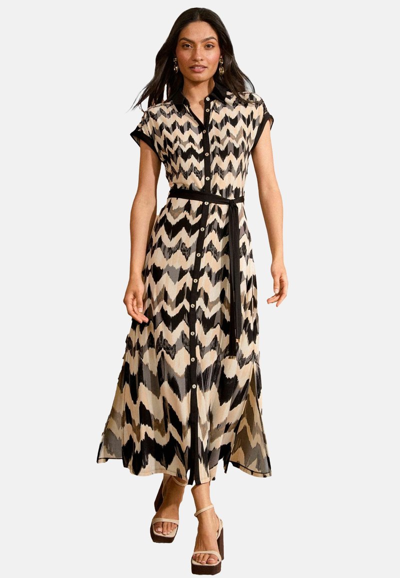 Rochie maxi cu un model în zig-zag în culorile negru, bej și maroniu. Mâneci scurte, deschidere cu nasturi, talie cu centură și material fluid.