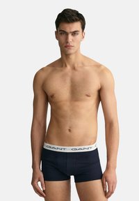 Boxer in blu navy con elastico in vita e logo in bianco. Tessuto liscio, design aderente e lunghezza fino a metà coscia.