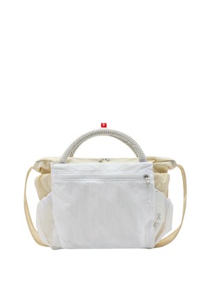 Witte en beige zachte stoffen tas met gevlochten, afgeronde handvatten, voorvak met rits en een beige schouderband, afgebeeld tegen een effen witte achtergrond.