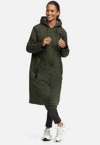 Long green parka with a hood, snap buttons, side pockets, and beige accents. Made of smooth, lightweight material, suitable for cool weather.