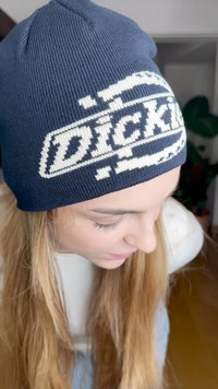 Laivastonsininen neulepipo, jossa on kontrastoiva valkoinen logo. Materiaali näyttää pehmeältä ja siinä on ribbikuvio, ja se kapenee ylhäältä.