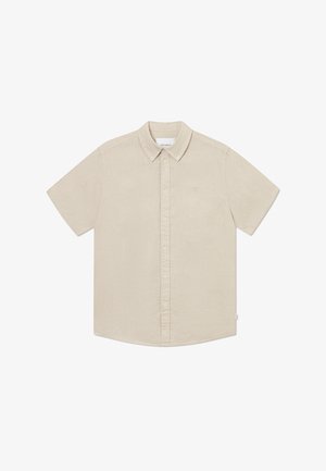 Camisa de manga corta y botones en un color beige claro, fabricada con una tela texturizada con un acabado suave y un sutil logo de la marca en el pecho.