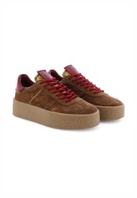 Braune Wildleder-Plateausneaker mit roten Schnürsenkeln, roten Leder-Hinterzwickeln und strukturierten beigen Gummisohlen, nebeneinander auf weißem Hintergrund platziert.