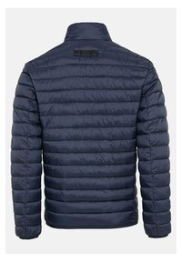 Marineblauwe gewatteerde jas met een horizontaal doorgestikt ontwerp, een staande kraag en een label op de rug, gemaakt van een gladde, lichte stof.