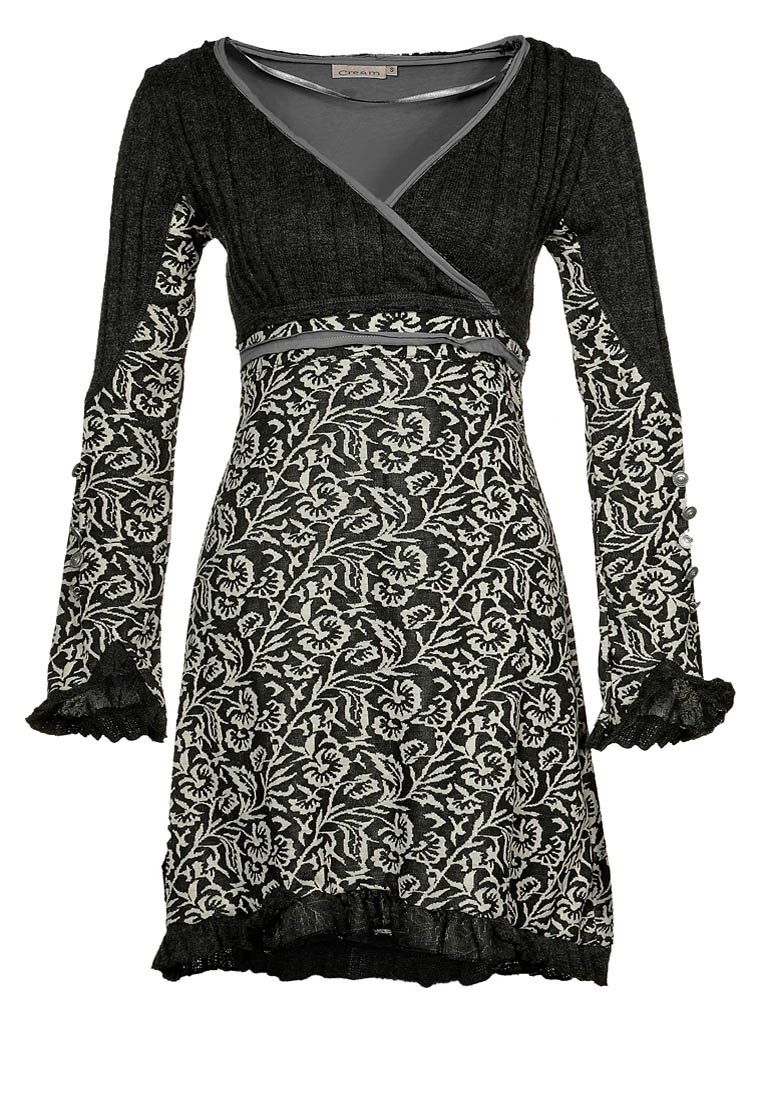 Svart och vit blommönstrad klänning med långa ärmar, volangdetaljer vid ärmsluten, en V-ringning och en figurnära midja. Tillverkad av texturerat stickat tyg.