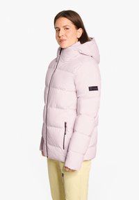Giacca puffer rosa chiaro con cappuccio, caratterizzata da un design trapuntato, zipper frontale e tasche laterali. Il materiale sembra liscio e isolato.