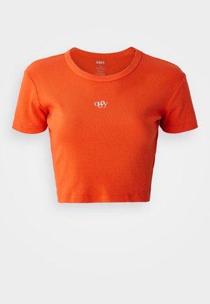 Kortsleeve oranž t-särk, mis on valmistatud ribakujulisest kangast, ümarate kaelusega ja rinnal on broderitud väike valge "obey" logo.