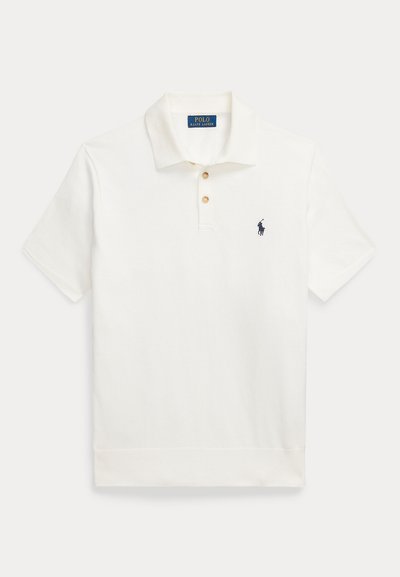 Bela polo majica iz bombaža, z klasičnim ovratnikom, trojnim gumbom in mornarsko modrim vezenim logotipom na levem prsnem delu.