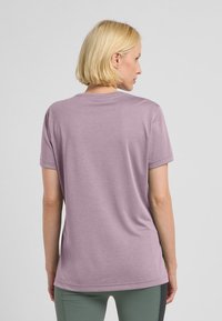 T-shirt corto viola con maniche corte, scollatura rotonda, texture morbida e vestibilità rilassata. Dettagli delle cuciture e orlo arrotondato discreto sul retro.