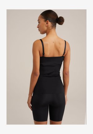 Black sleeveless top with adjustable straps and fitted design. Soft, smooth fabric paired with black high-waisted shorts.