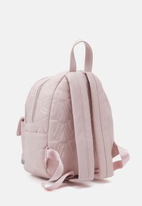 Quilted rosa ryggsäck med rundad form, utrustad med dubbla axelremmar, dragkedjestängning och en sidoficka. Slät yta med geometriskt mönster.