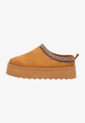 Scarpa slip-on in suede color sabbia con un bordo di trame marroni strutturate e una suola in gomma spessa e scanalata per una migliore aderenza.