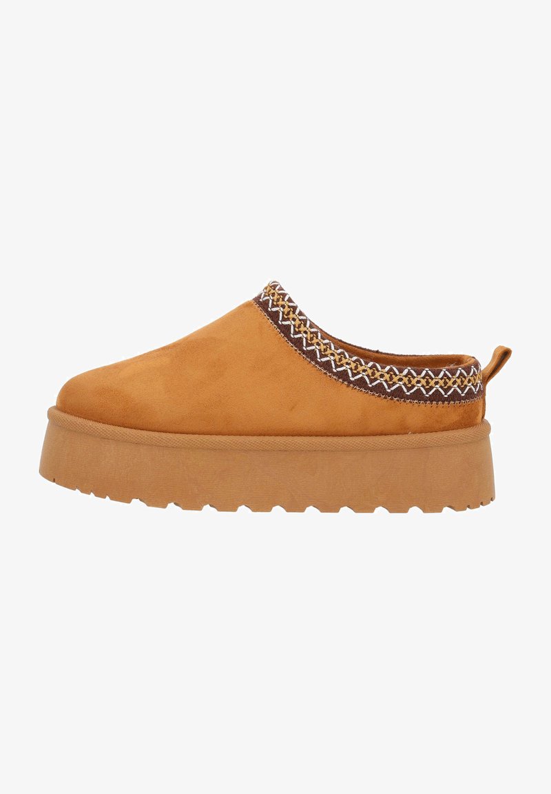 Chaussure slip-on en suède beige avec une bordure texturée à motif marron et une semelle en caoutchouc épaisse et nervurée pour une bonne adhérence.