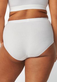 Slip bianchi a vita alta realizzati in morbido cotone, con un elastico ondulato in vita e bordi senza cuciture per il massimo del comfort.