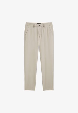 Lichtbeige broek van gladde stof. Voorzien van een knoopsluiting, zijzakken en een taps toelopend ontwerp. Klassieke, minimalistische stijl.