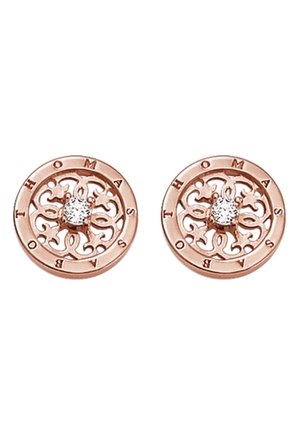 Boucles d'oreilles rondes en or rose avec un design filigrané complexe et une pierre précieuse claire au centre, gravées "THOMAS SABO" autour du bord.