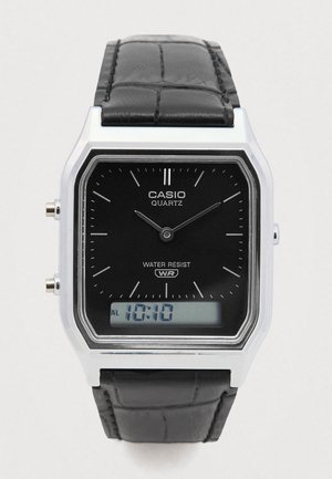 Casio kvarca rokas pulkstenis ar melnu analogo ciparu, sudraba korpusu, melnu ādas siksnu un digitālo displeju, kas rāda 10:10.