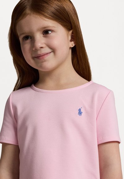 Svetlo roza kratkotrajna majica s kratkimi rokavi in okroglo ovratnikom, z modrim izvezenim logotipom na levi prsni strani. Mehka bombažna tkanina z gladko teksturo.