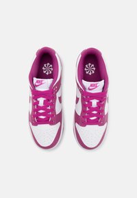Nike sportcipő fehér bőr felső résszel és élénk rózsaszín díszítésekkel. Jellemzői közé tartozik a rózsaszín cipőfűző, perforált orr és virágmintás talpbetét.