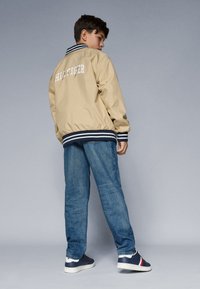 Tommy Hilfiger REVERSIBLE JACKET UNISEX - Pilotska jakna - gentle gold coloured/dark night navy