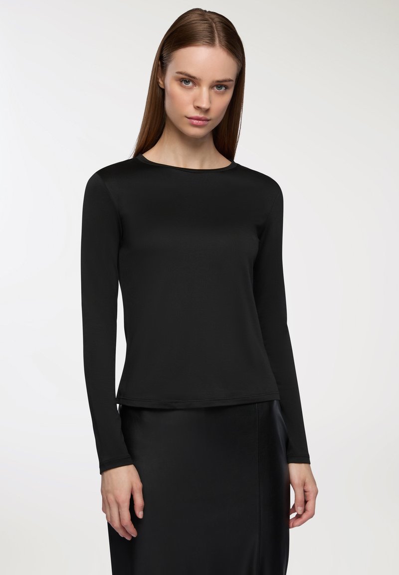 Czarna bluzka z długim rękawem i okrągłym dekoltem, wykonana z gładkiego materiału. Projekt charakteryzuje się dopasowaną sylwetką i sięga do bioder.