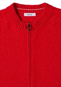 Maglione rosso con zip e colletto a costine, dotato di un tirante della zip nero e un motivo a maglia testurizzato. L'etichetta riporta "CECIL."