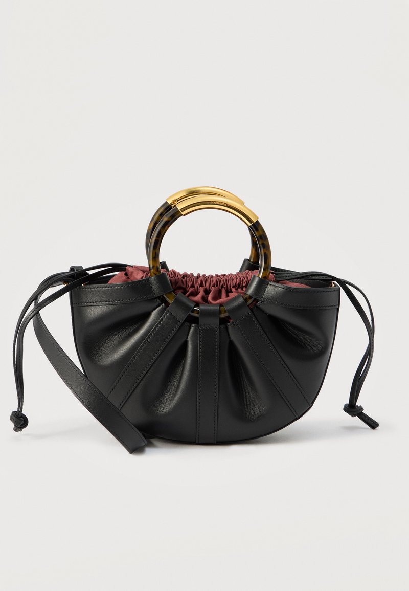 Μαύρο δερμάτινο τσάντα ημισεληνοειδούς σχήματος με ρυτιδωτό μπορντό ύφασμα στην κορυφή και κυκλικές λαβές από χελώνα και χρυσό, με μακρύ ρυθμιζόμενο ιμάντα.
