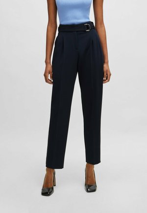 Pantaloni alta vita color navy con cintura e fibbia, caratterizzati da pieghe e una vestibilità sartoriale, realizzati in un tessuto leggero e morbido.