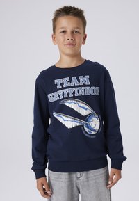Sudadera azul marino con el texto "EQUIPO GRYFFINDOR" y un motivo de Quidditch con acentos en blanco y azul. Puños y dobladillo de canalé.