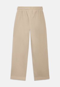 Μπεζ παντελόνι με φαρδιά μπατζάκια και υφή, με ελαστική μέση. Διαθέτει μοτίβο σχημάτων πλέγματος και δεν έχει ορατά μεταλλικά στοιχεία ή διακοσμητικά.