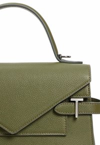 Borsa a tracolla verde in pelle con design strutturato, superficie testurizzata, hardware in tonalità argento e chiusura a pattina triangolare con un accento a forma di 'T'.