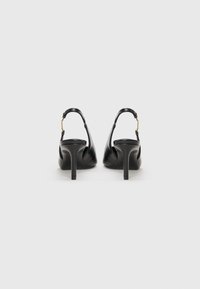 Musta nahkainen slingback-korkokenkä, jossa on teräväkärkinen muoto ja kapea korko. Takakatselussa on soljettimen kiinnitys ja sileä, kiiltävä pinta.