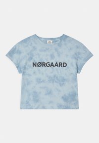 Jasnoniebieska koszulka tie-dye z krótkimi rękawami i okrągłym dekoltem, z napisem "NØRGAARD" w grubych czarnych literach na piersi.