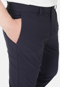Pantaloni blu navy con una texture liscia, dotati di tasca laterale, taglio affusolato e vita elasticizzata per comfort e libertà di movimento.