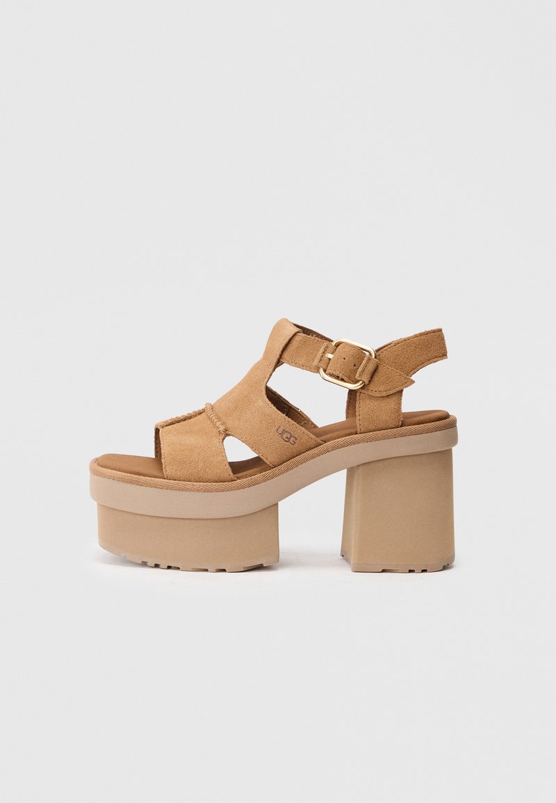 Sandalias de plataforma de ante marrón con punta abierta, diseño recortado, correa ajustable con hebilla dorada y tacón grueso beige.