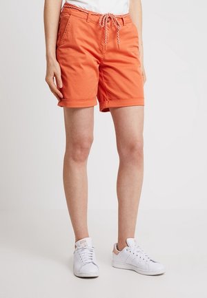 Shorts orange en tissu coton, avec une taille élastique à cordon au design contrasté et des ourlets roulés. Assortis avec des baskets blanches.