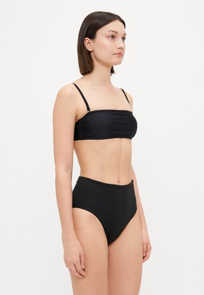 Mustat bikinit, joissa on bandeau-toppi ohuilla olkaimilla ja korkea vyötärö. Sulava, joustava materiaali minimalistisella suunnittelulla.