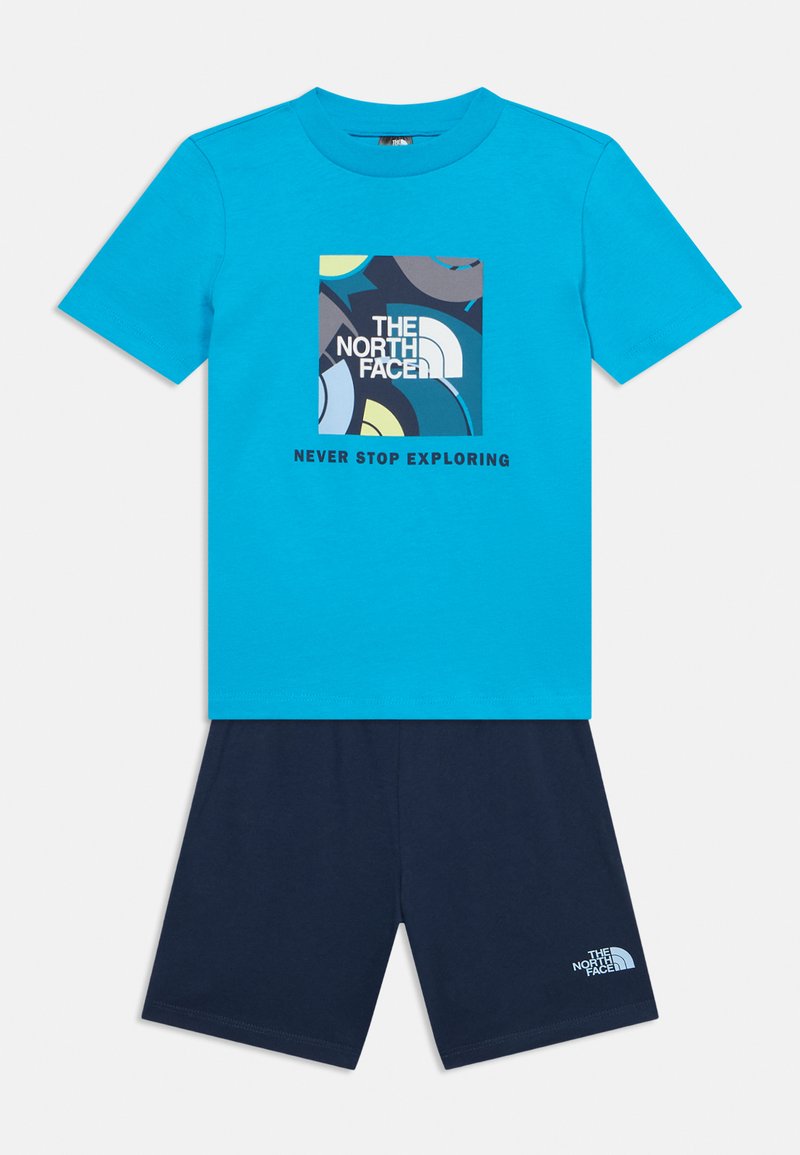 Μπλε T-shirt με κοντά μανίκια, με πολύχρωμο αφηρημένο τετράγωνο και το κείμενο "The North Face Never Stop Exploring", σε συνδυασμό με σκούρα μπλε σορτς με λογότυπο.