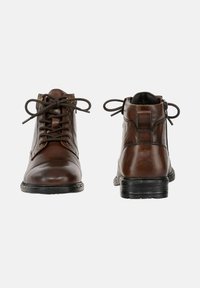 Brązowe skórzane botki za kostkę z sznurówkami i zamkiem błyskawicznym z tyłu, zaokrąglony nosek, teksturowane wykończenie oraz czarne gumowe podeszwy.