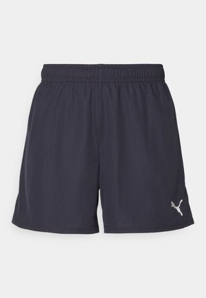 Mørkeblå fritidsbukser laget av lett materiale, med elastisk midjebånd og en liten hvit logo på venstre side.