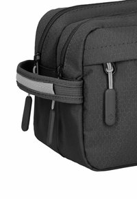 Borsa nera in tessuto con texture esagonale, due scomparti con cerniera e un manico grigio in contrasto. Presenta tirazip e hardware grigi.
