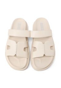 Infradito beige in morbido gomma, con una larga fascia decorata da un motivo traforato, suola testurizzata e leggera imbottitura.