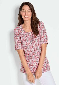 Korte mouwen top in een roze blompatroon met een ronde hals. Gemaakt van lichte stof met een gladde textuur. Heeft een ontspannen pasvorm.
