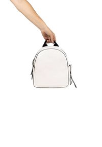 Mochila de cuero blanca con un diseño redondeado, acentos en negro, cremalleras dobles y un asa superior, representada en una posición sostenida a mano.