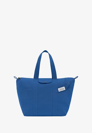 Blue fabric tote bag with two shoulder straps, button closure, front pocket, and label detail. Smooth texture with structured shape.