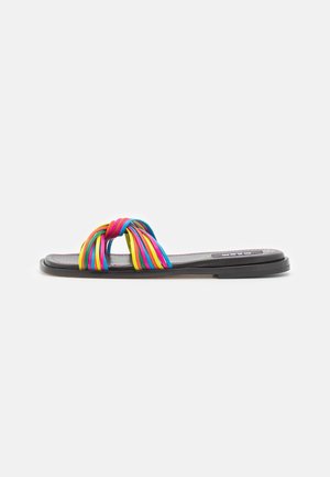 Sandalias planas que presentan una correa trenzada multicolor en rosa, azul y amarillo, con una suela negra y un acabado suave y mate.