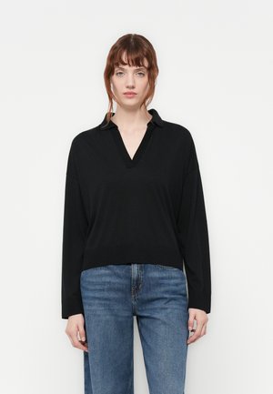 Svart langermet genser med V-hals og krage. Har en avslappet passform og ribbestrikket kant. Brukt med blå jeans.