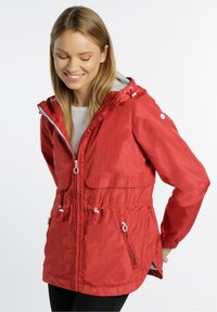 Rote wasserdichte Jacke mit Kapuze, elastischem Zugband in der Taille und mit Reißverschlusstaschen. Sie hat eine glänzende Textur und einen kontrastierenden grauen Innenfutter.