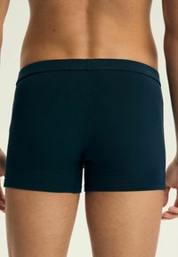 Granatowe bokserki z elastycznego materiału, z gładką talią, dopasowanym krojem i bezszwowym wykończeniem z tyłu dla wygody i elastyczności.